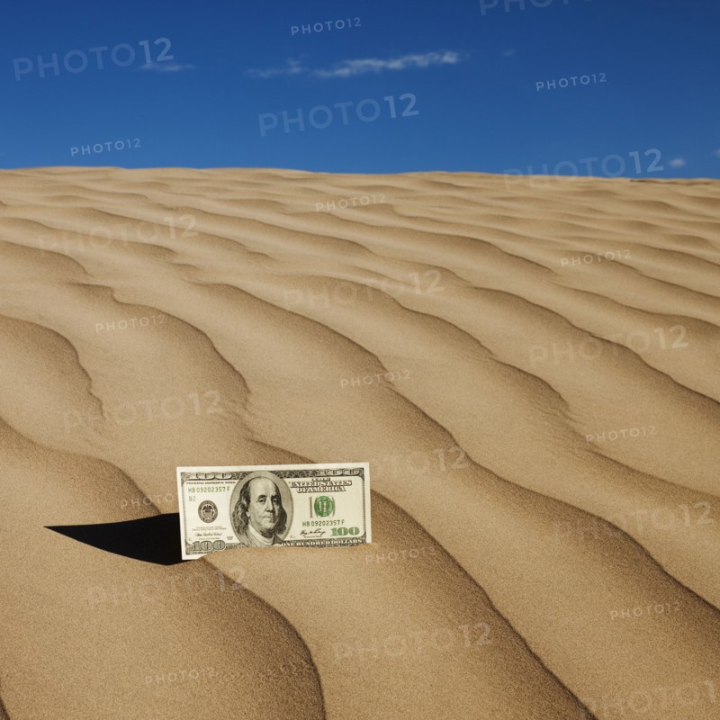100 dollar bill on sand in desert. Photo. Mike Kemp