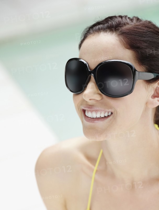Brunette wearing large sunglasses. Photo : momentimages