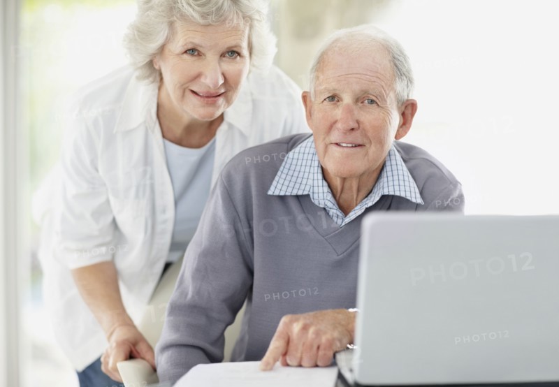 Senior couple doing paperwork together. Photo. momentimages