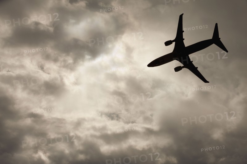 Commercial jet in cloudy sky. Photo. Mike Kemp