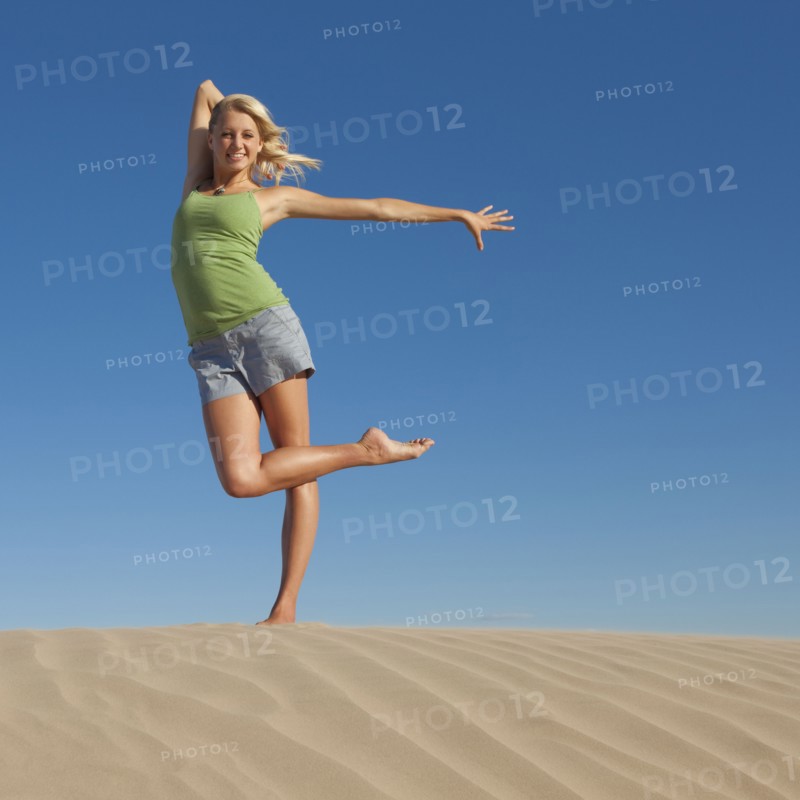 Woman doing dance pose at the beach. Photo. Mike Kemp
