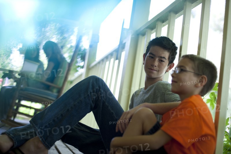 Two young boys sitting on porch. Photo. Tim Pannell