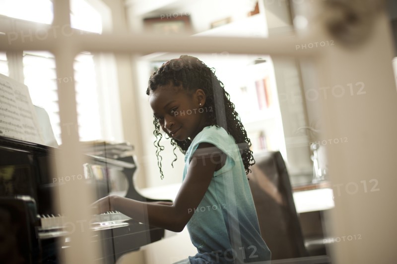 Young girl playing piano. Photo. Tim Pannell