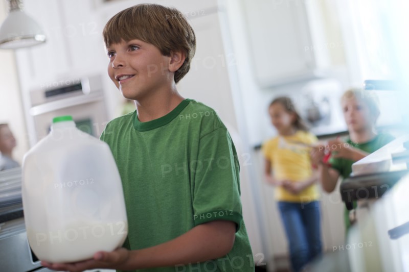 Young boy carrying jug of milk. Photo. Tim Pannell