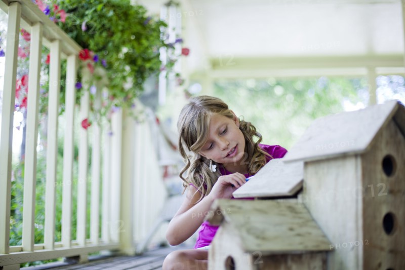 Young girl painting a birdhouse. Photo. Tim Pannell