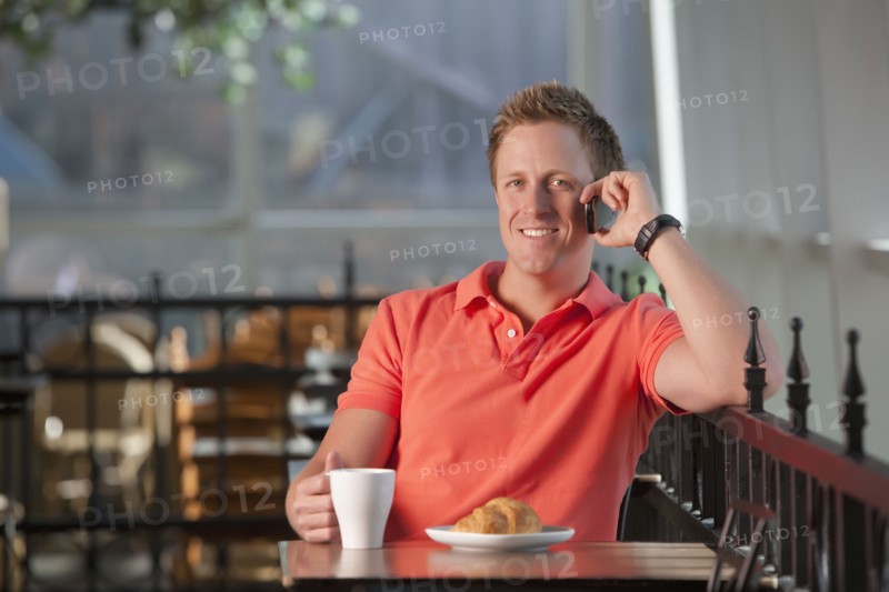 Man sitting on patio at cafe. Photo. Dan Bannister