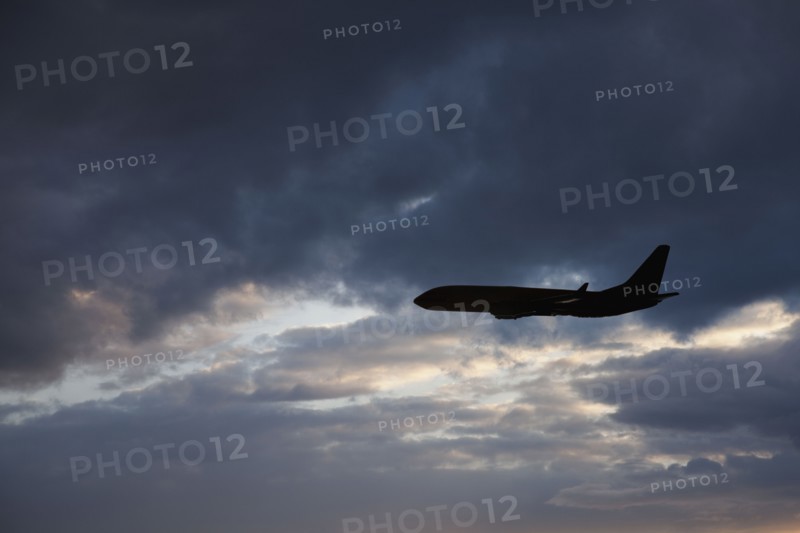 Commercial jet in cloudy sky. Photo. Mike Kemp