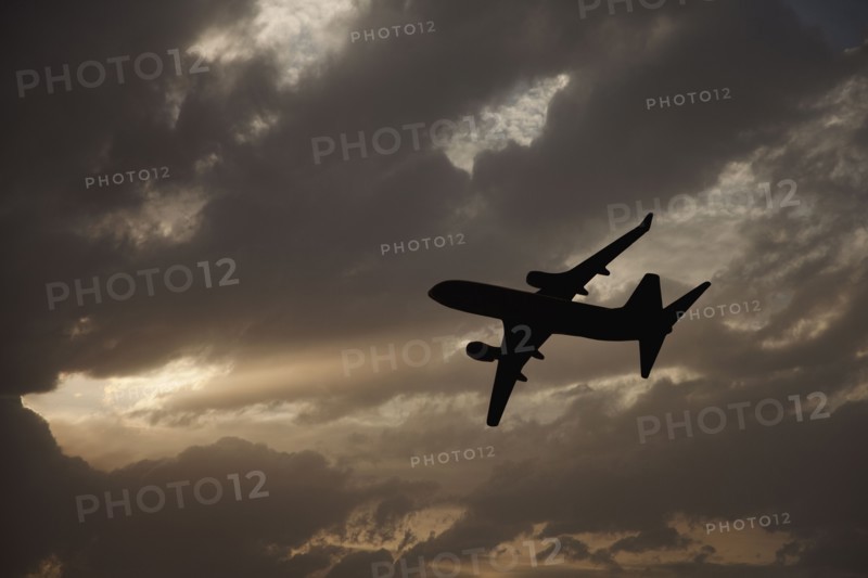 Commercial jet in cloudy sky. Photo. Mike Kemp