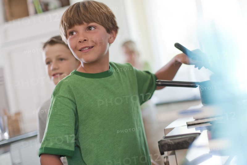 Young boy stirring food on stove. Photo. Tim Pannell