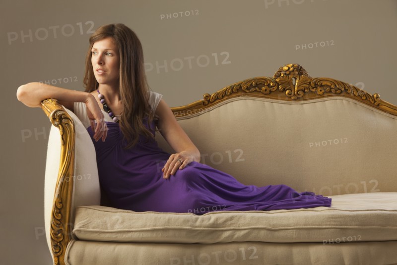 Elegant woman lounging on antique sofa. Photo : Mike Kemp