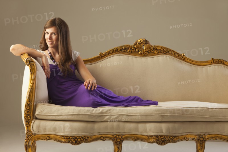 Elegant woman lounging on antique sofa. Photo : Mike Kemp