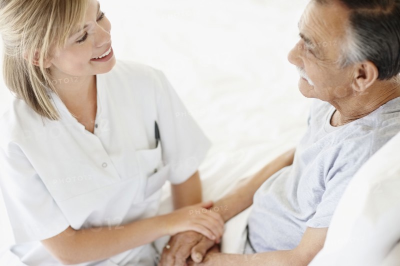 Nurse sitting with patient. Photo : momentimages