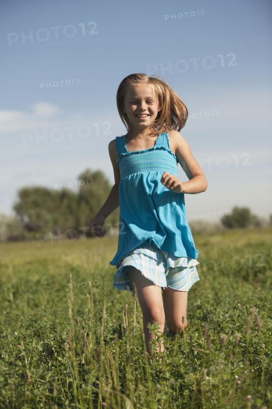 Young girl running in field. Photo. Mike Kemp