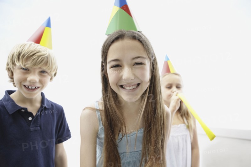 Three children wearing birthday hats. Photo. momentimages