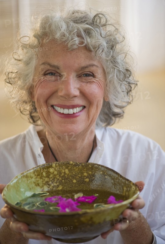 Woman holding bowl of flower petals. Photo. Daniel Grill