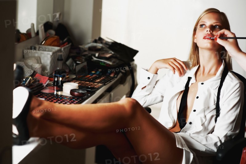 Attractive blond model sitting at vanity. Photo. momentimages