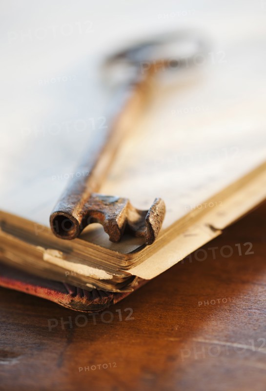 Antique key on top of book.