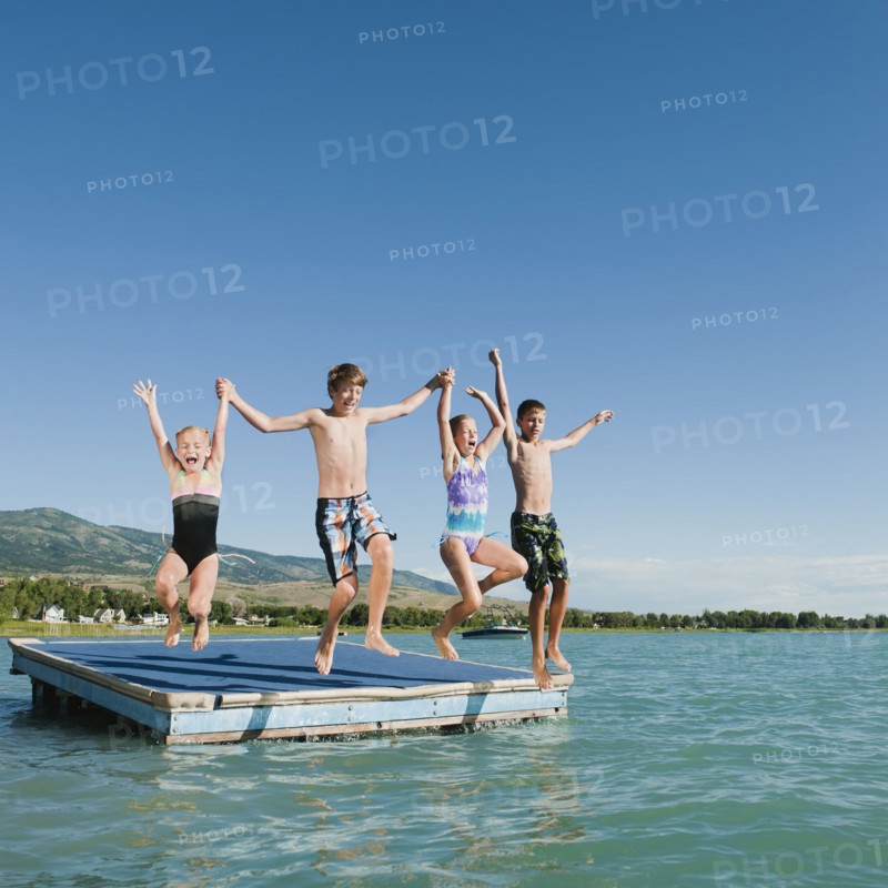 Kids (6-7,8-9,10-11,12-13) playing on raft on lake.