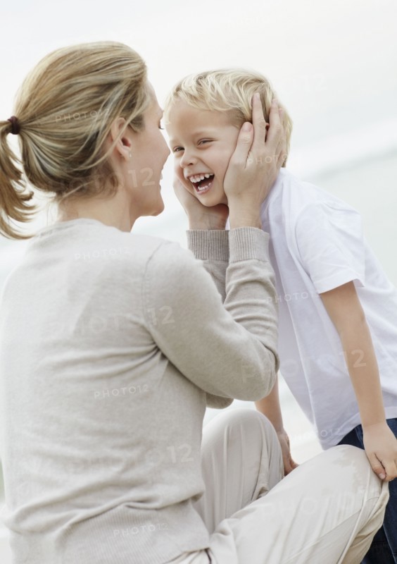 Boy (4-5) playing on beach with mother. Photo : Momentimages