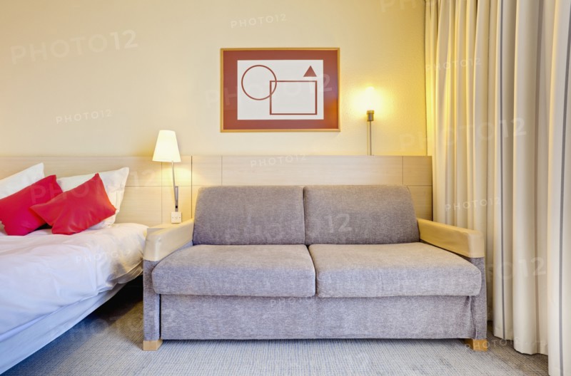 Sofa beside bed in luxury home. Photo : Jon Boyes