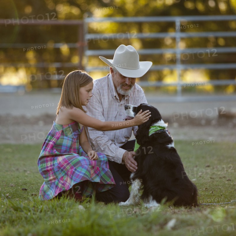 Girl (8-9) stroking dog with grandfather. Photo : Mike Kemp