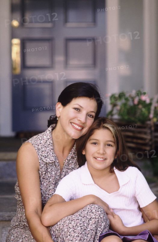 Mother and daughter sitting in front of their home. Photo : Fisher Litwin