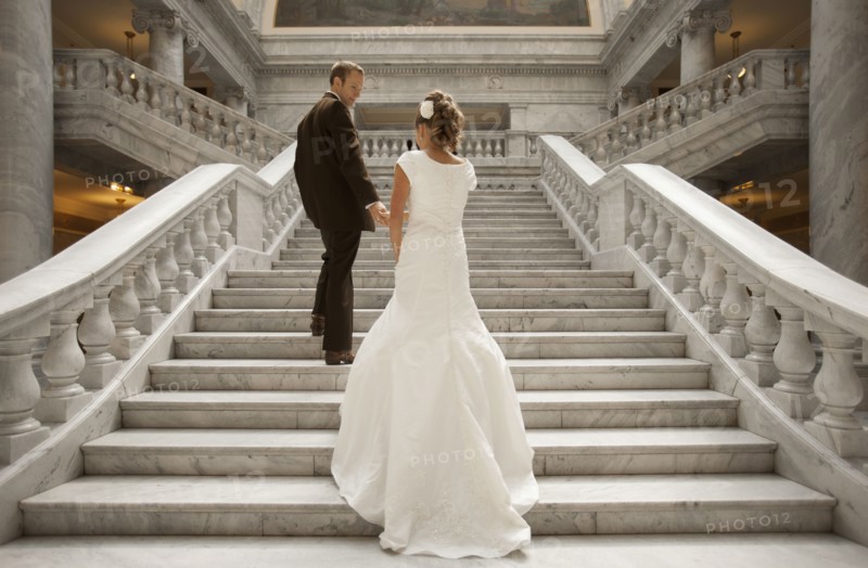 Bride and groom holding hands on steps. Photo : FBP