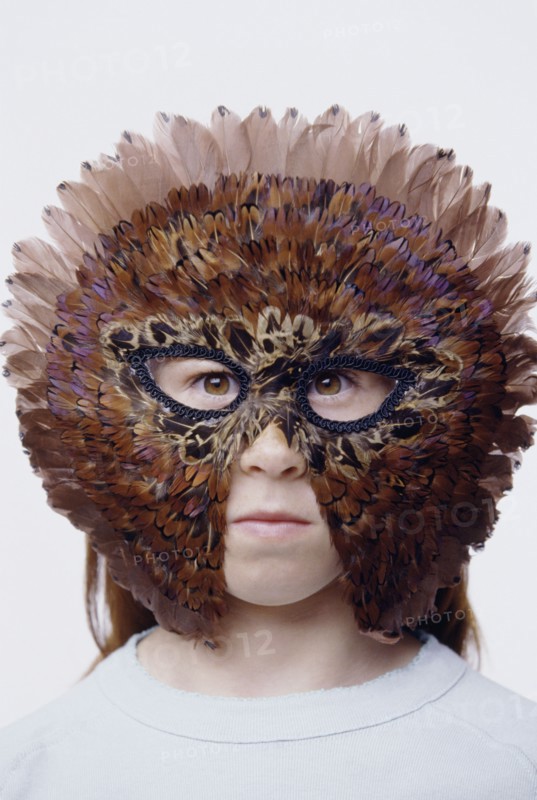 Child wearing a feather mask. Photo : Fisher Litwin