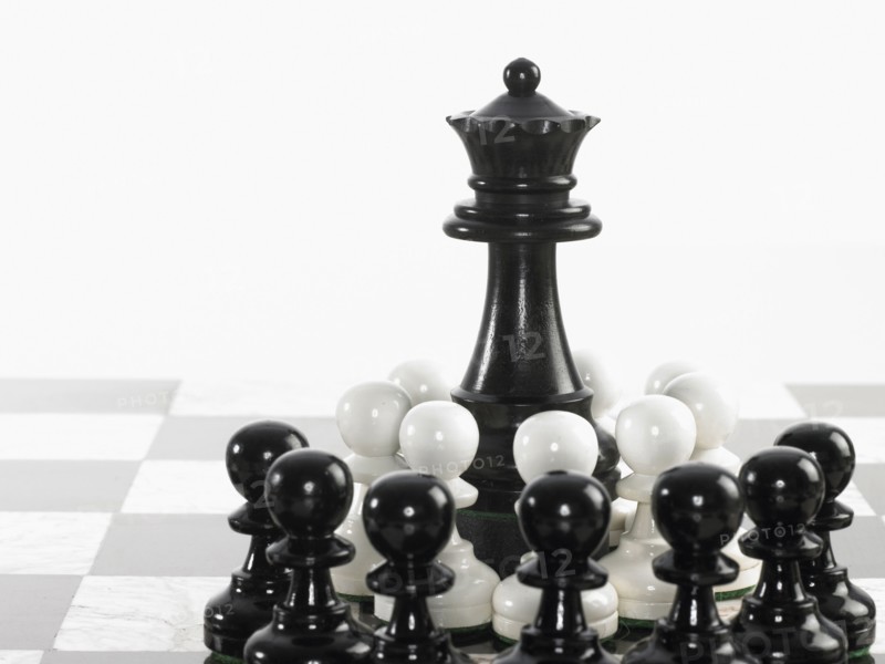 Queen surrounded by pawn chess pieces. Photo : David Arky