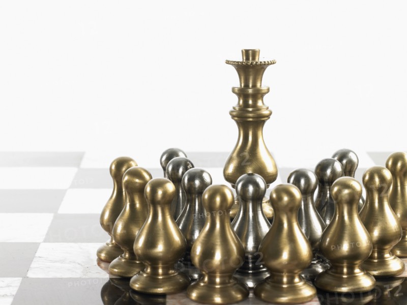 Queen surrounded by pawn chess pieces. Photo : David Arky