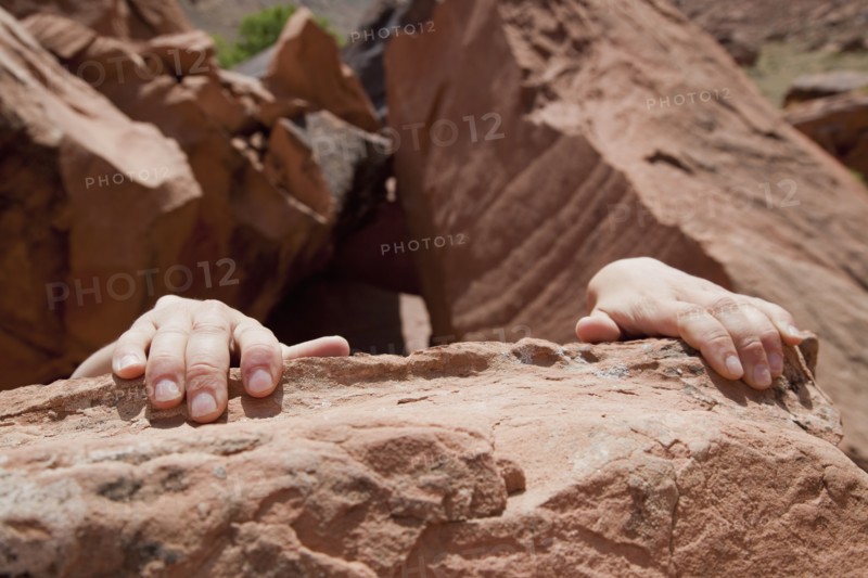 Young woman's hands on rocks. Photo : Johannes Kroemer
