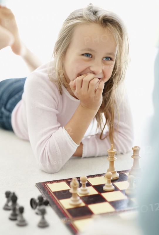 Girl (10-11) playing chess. Photo : Momentimages