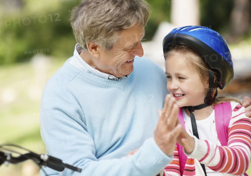 Happy grandfather and granddaughter (10-11) with bike. Photo : Momentimages