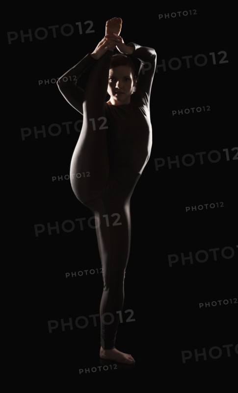 Female contortionist on black background. Photo : Mike Kemp