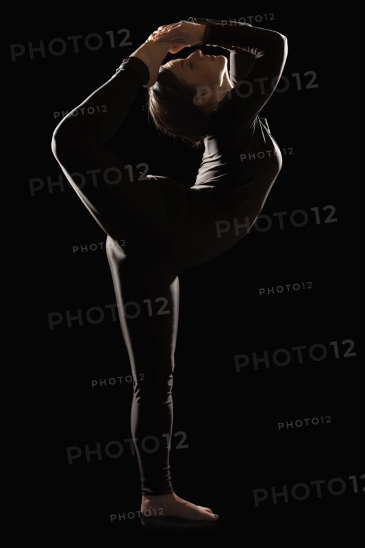 Female contortionist on black background. Photo : Mike Kemp