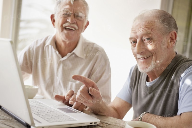 Senior men using laptop. Photo : Momentimages