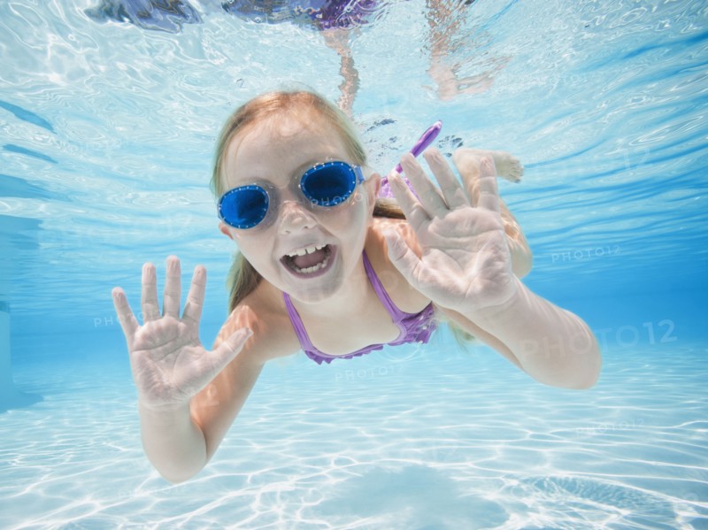 Girl (6-7) swimming underwater.