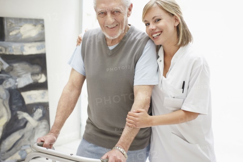 Nurse assisting patient in corridor of clinic. Photo : Momentimages