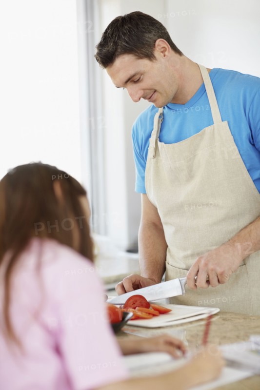 Daughter (10-11) helping father prepare meal . Photo : Momentimages