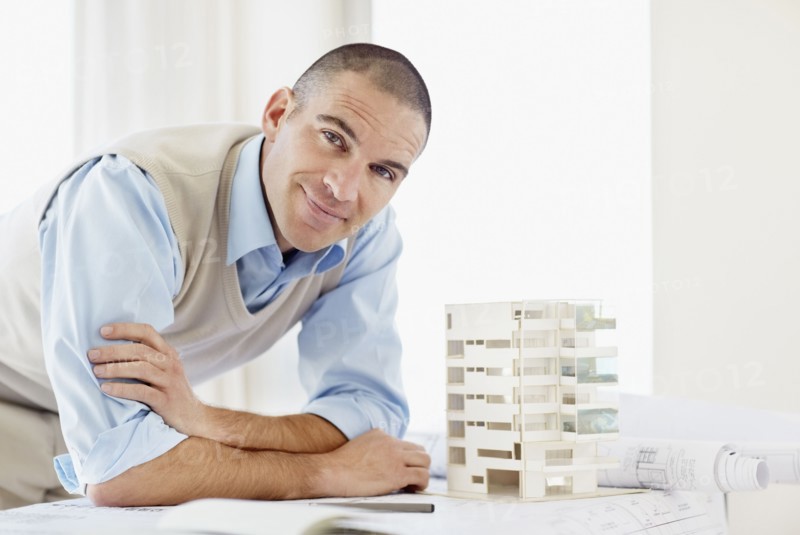 Portrait of architect with apartment model. Photo : Momentimages