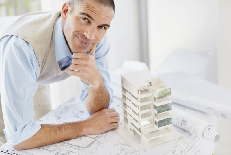 Portrait of architect with apartment model. Photo : Momentimages