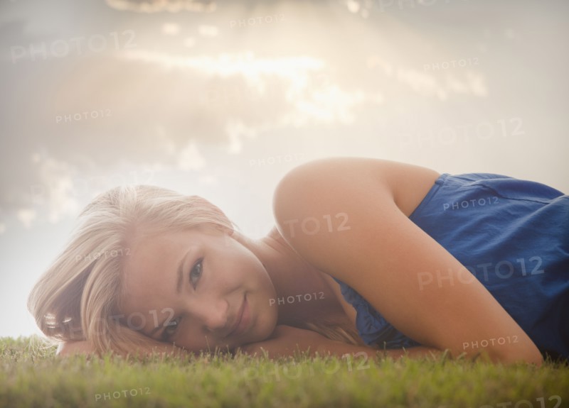 Young girl (16-17) lying on grass. Photo : Mike Kemp