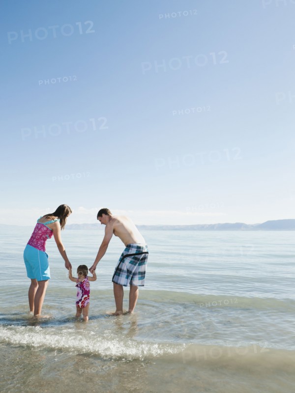 Parents with baby daughter (12-18months) playing on holidays.