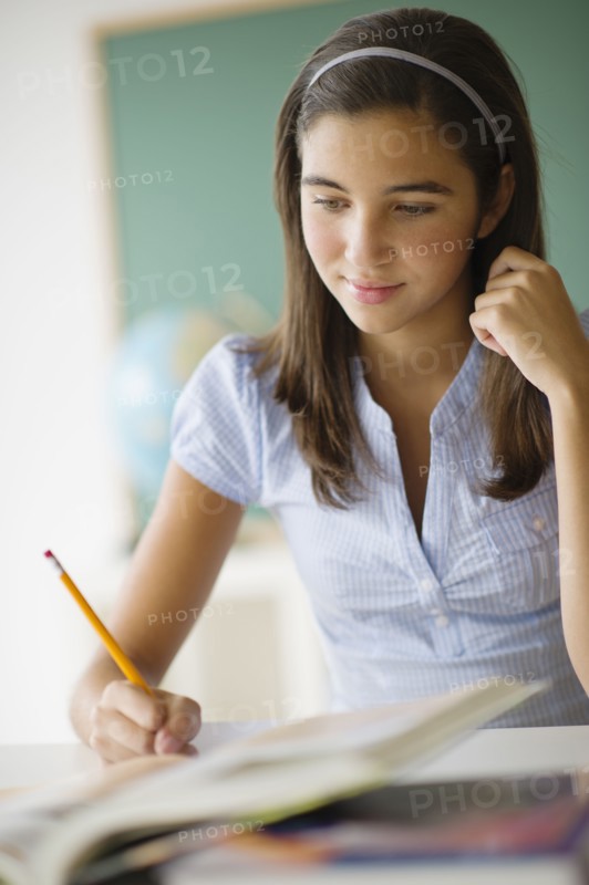 Schoolgirl (12-13) writing.