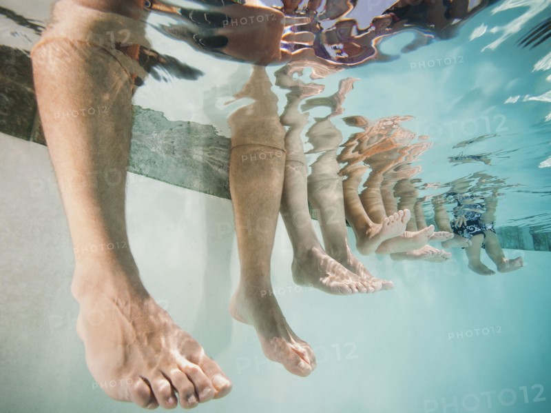 Family with four kids (12-18months, 4-5,6-7,8-9) on swimming pool.