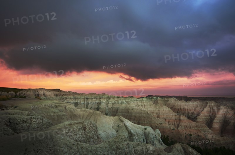 USA, South Dakota, Thick gray clouds over mountains in Badlands National Park at sunset.