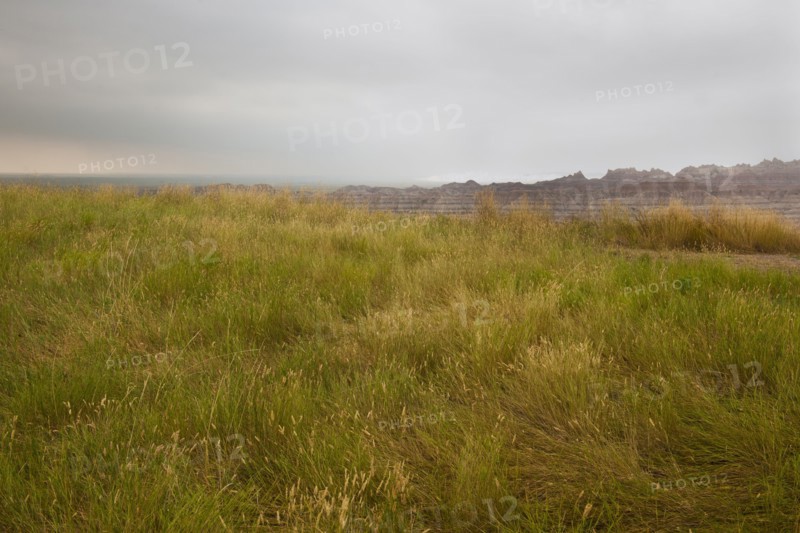 USA, South Dakota, Stormy clouds over prairie grass in Badlands National Park.