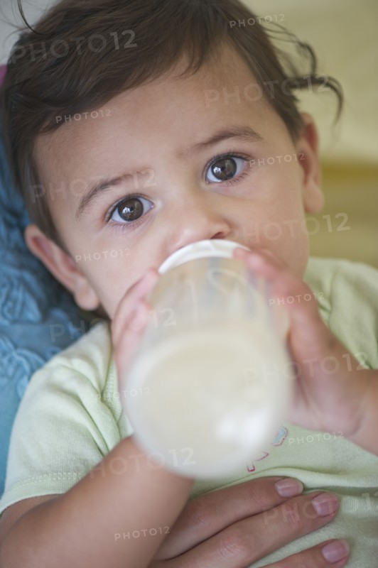 Mother feeding baby daughter (12-18 months) .