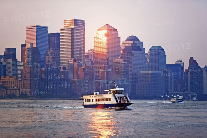 USA, New York State, New York City, Ferry on river and World Financial Center at sunset. Photo : fotog