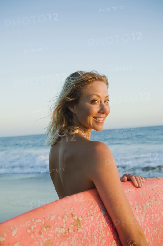 Portrait of woman with surfboard.